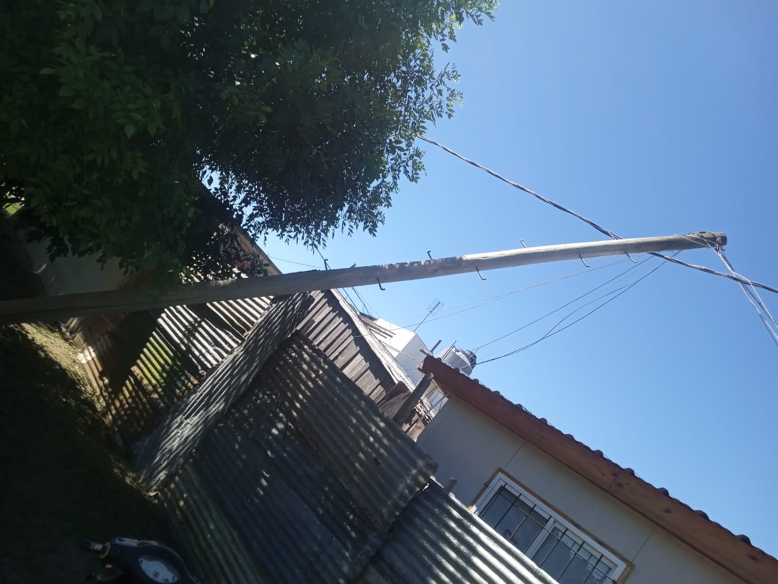 Vecino convive hace casi una semana con un poste a punto de caerse sobre su casa