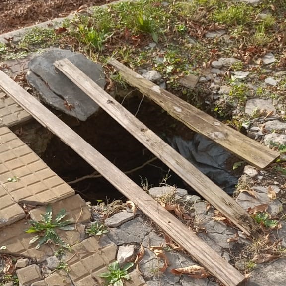 Enorme pozo en la vereda: Le pusieron tablas porque se roban las chapas cuando lo tapan