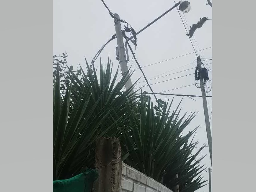 13 y 98: Un poste está a punto de caerse sobre una casa