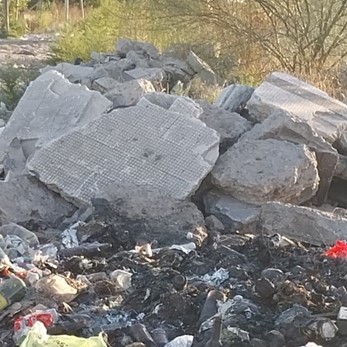 Vecina de Los Hornos denunció que operarios de la comuna dejaron pedazos de veredas en un basural