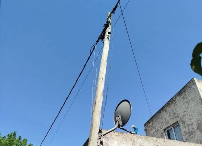 Poste agarrado de los cables sobre una vivienda